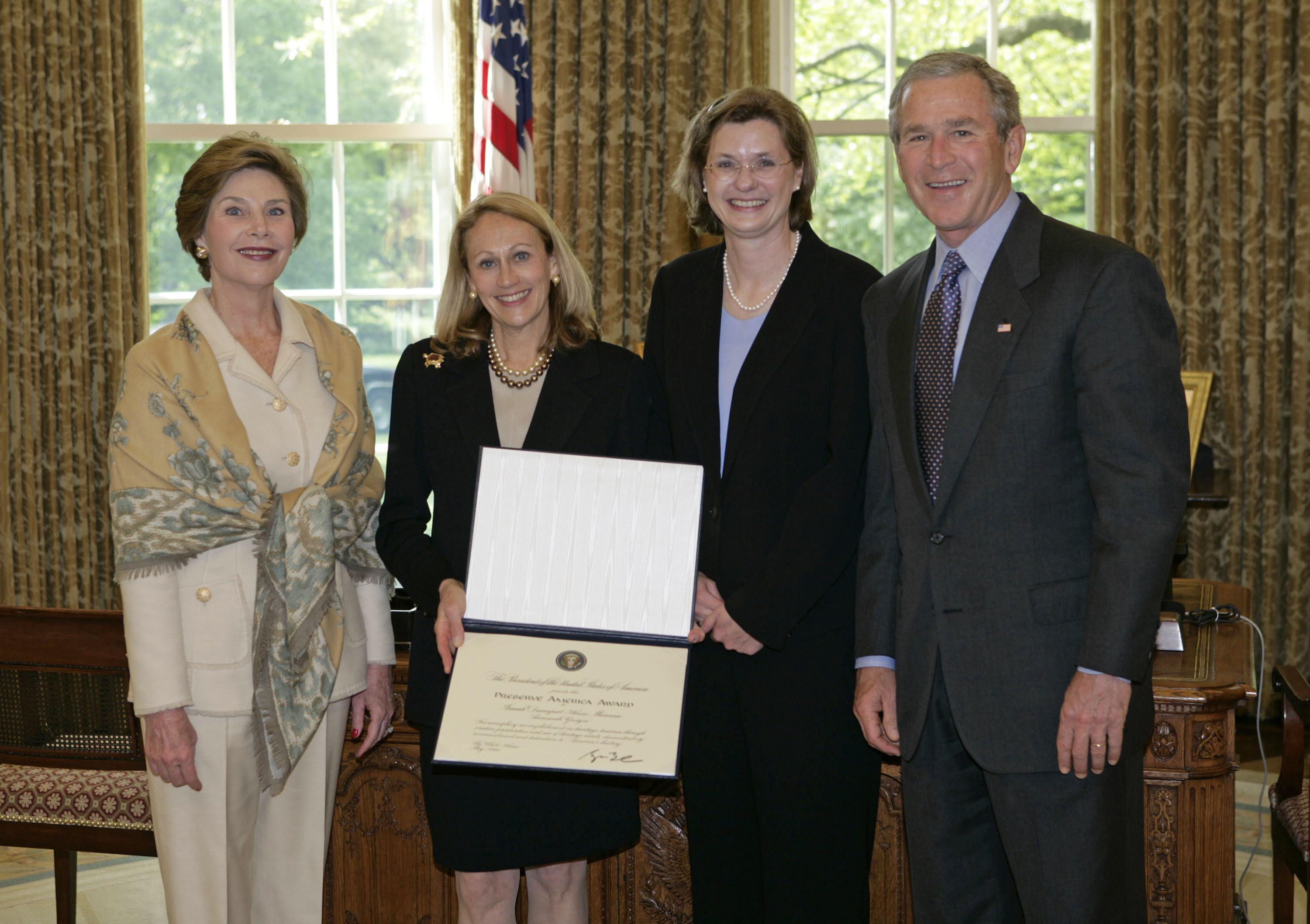 President George W. Bush and Laura Bush present the 2005 Preserve America Presidential Award to Zelda Tenenbaum, President, Board of Trustees, Historic Savannah Foundation, left, and Jamie Credle, Director, Isaiah Davenport House Museum, both of Savannah, Georgia, in the Oval Office Monday, May 2, 2005. (White House photo by Eric Draper)
