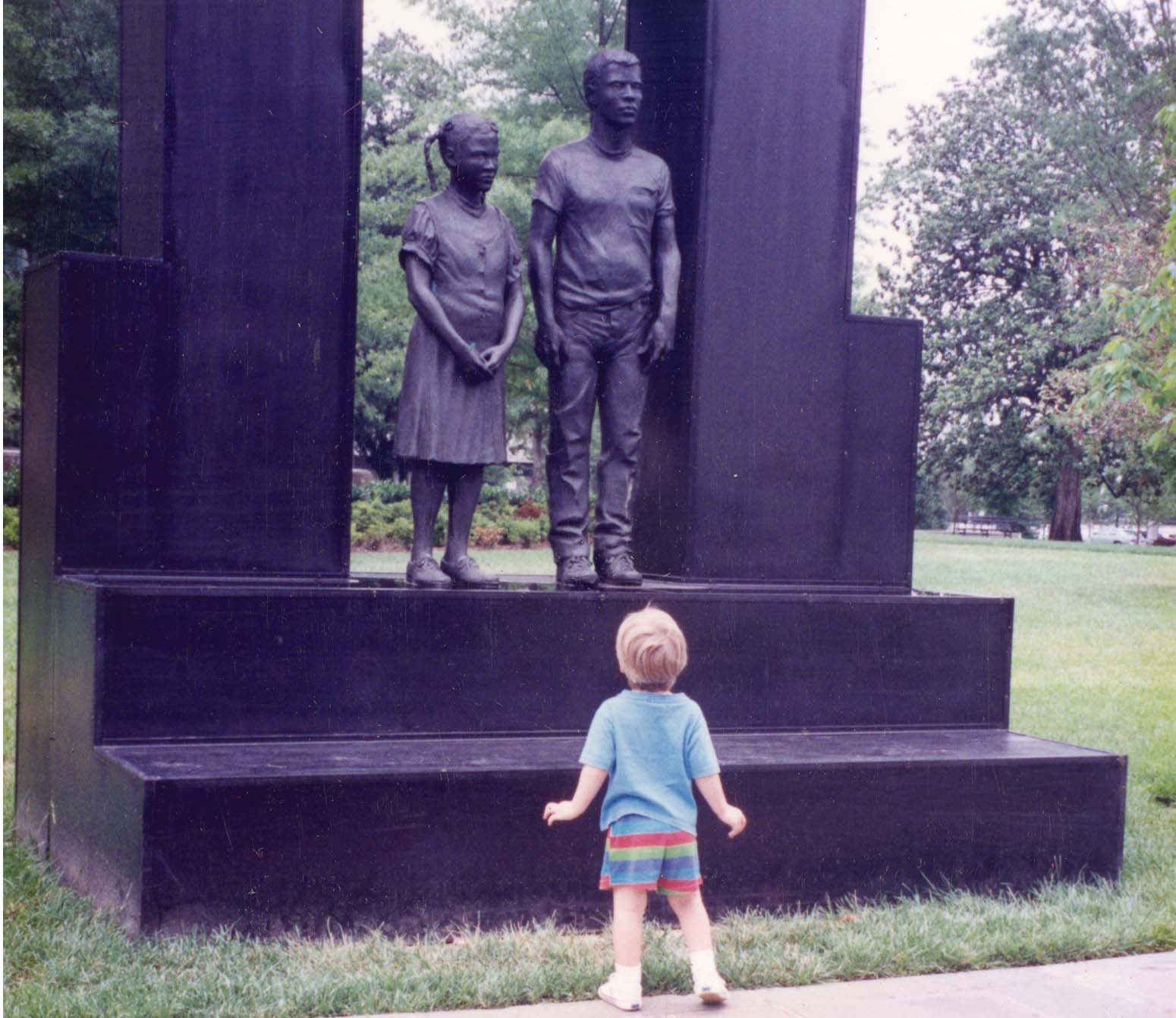A child looks up at a sculpture commemorating the Children's March in Kelly Ingram Park at the Civil Rights Museum