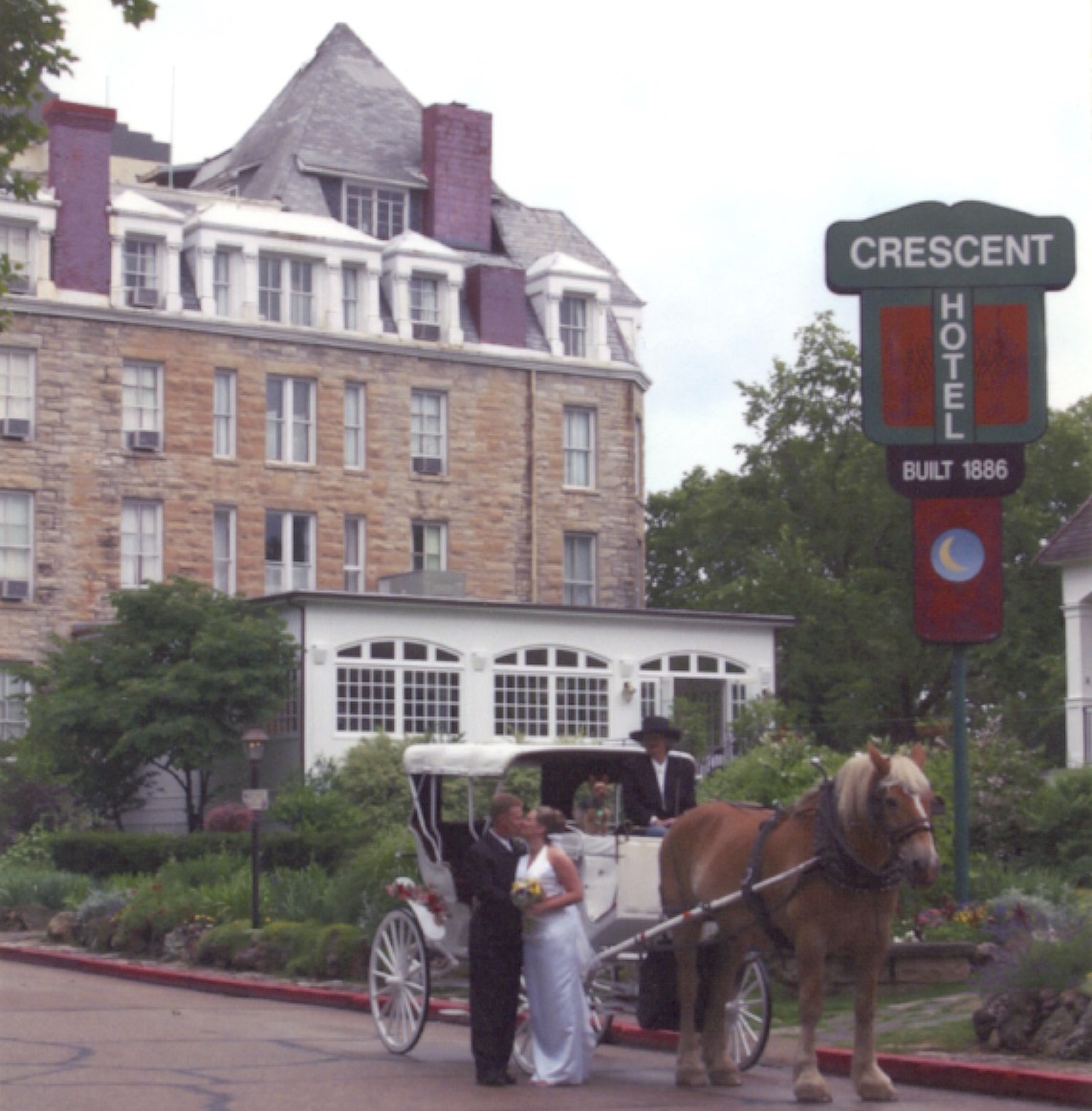 A newly married couple poses in front of the Crescent Hotel (1886) in historic Eureka Springs, Arkansas