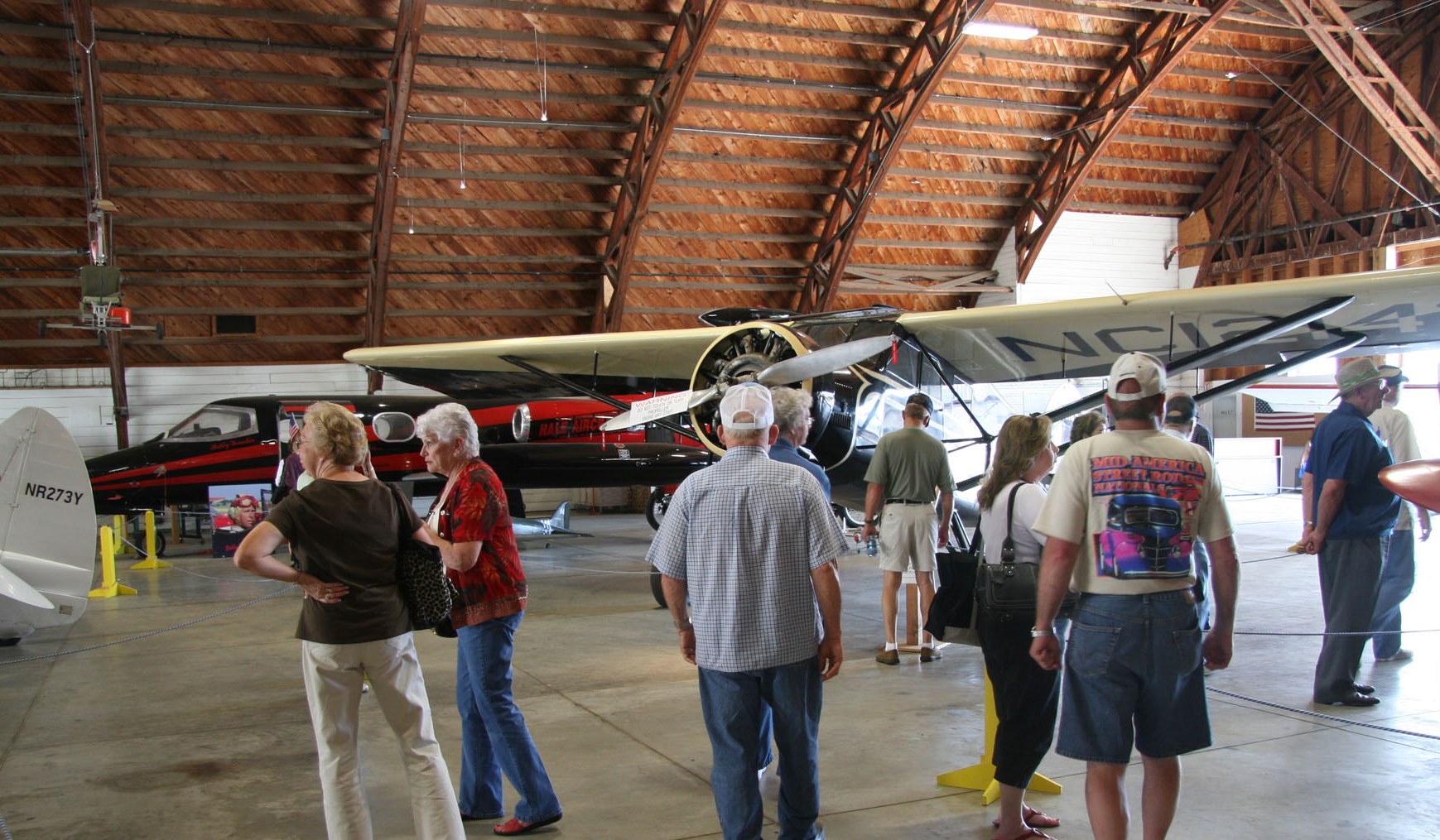 Visitors examine aircraft in White Hangar at Drake Field in Fayetteville, Arkansas, one of only a dozen remaining WWII-era aircraft hangars.