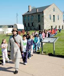 Young visitors to historic Fort Smith explore the historic site with a costumed guide