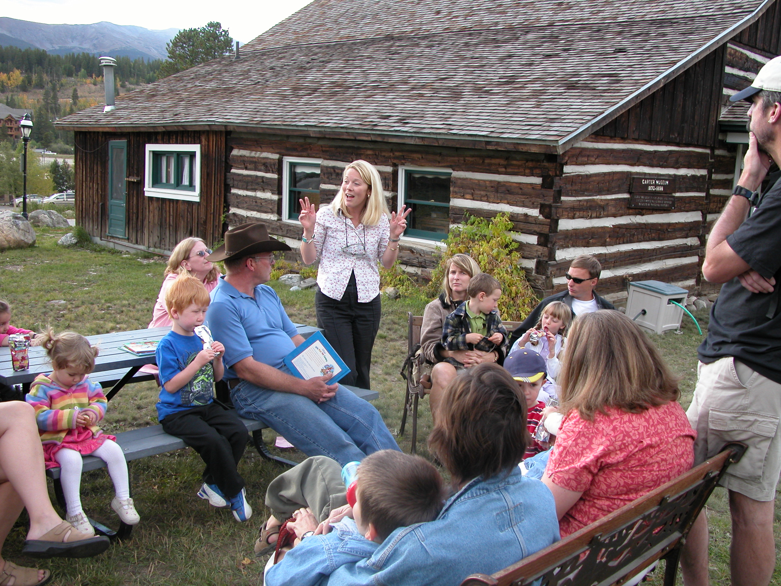 Story hour in front of a restored 1875 cabin at the Edwin Carter Museum in Breckenridge, Colorado. 