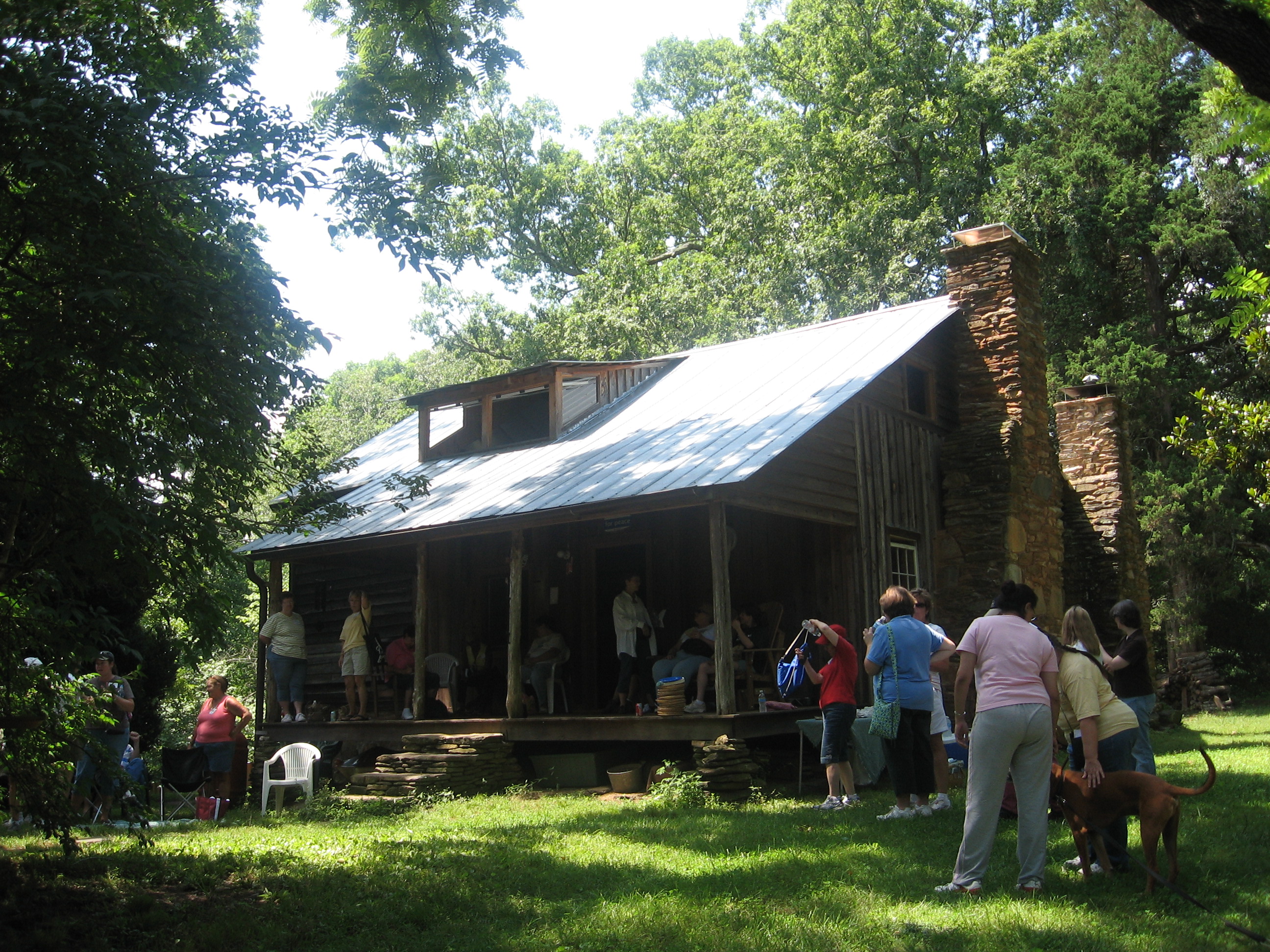 Visitors at the circa 1843 Power Cabin, one of the rare examples of a single-pen (one room) log house remaining in Cobb County. Although a framed addition was added later, the original hand-hewn, squared-and-notched log construction is still visible.