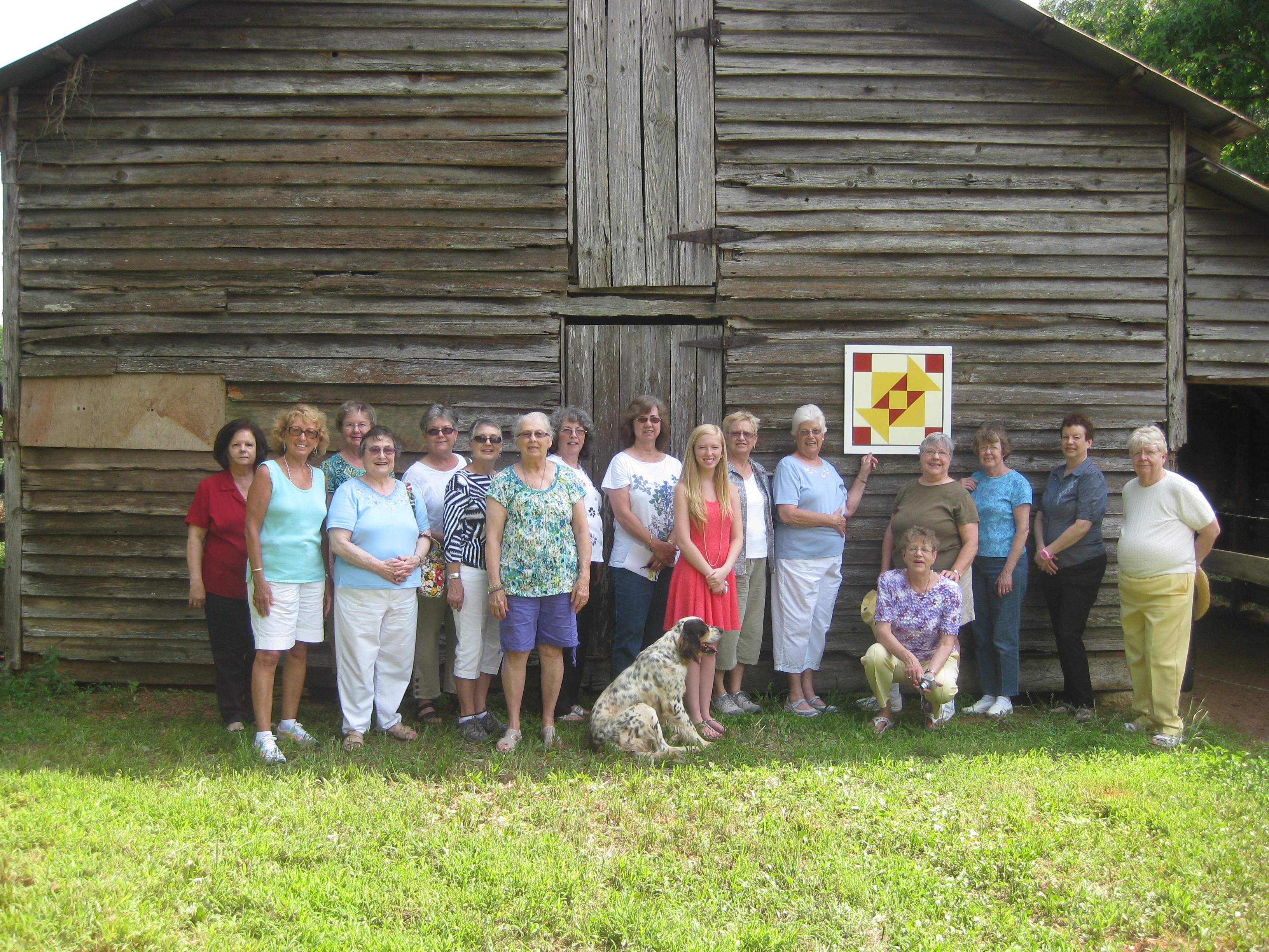 A group outside a historic barn on the Hart County Quilt Trail