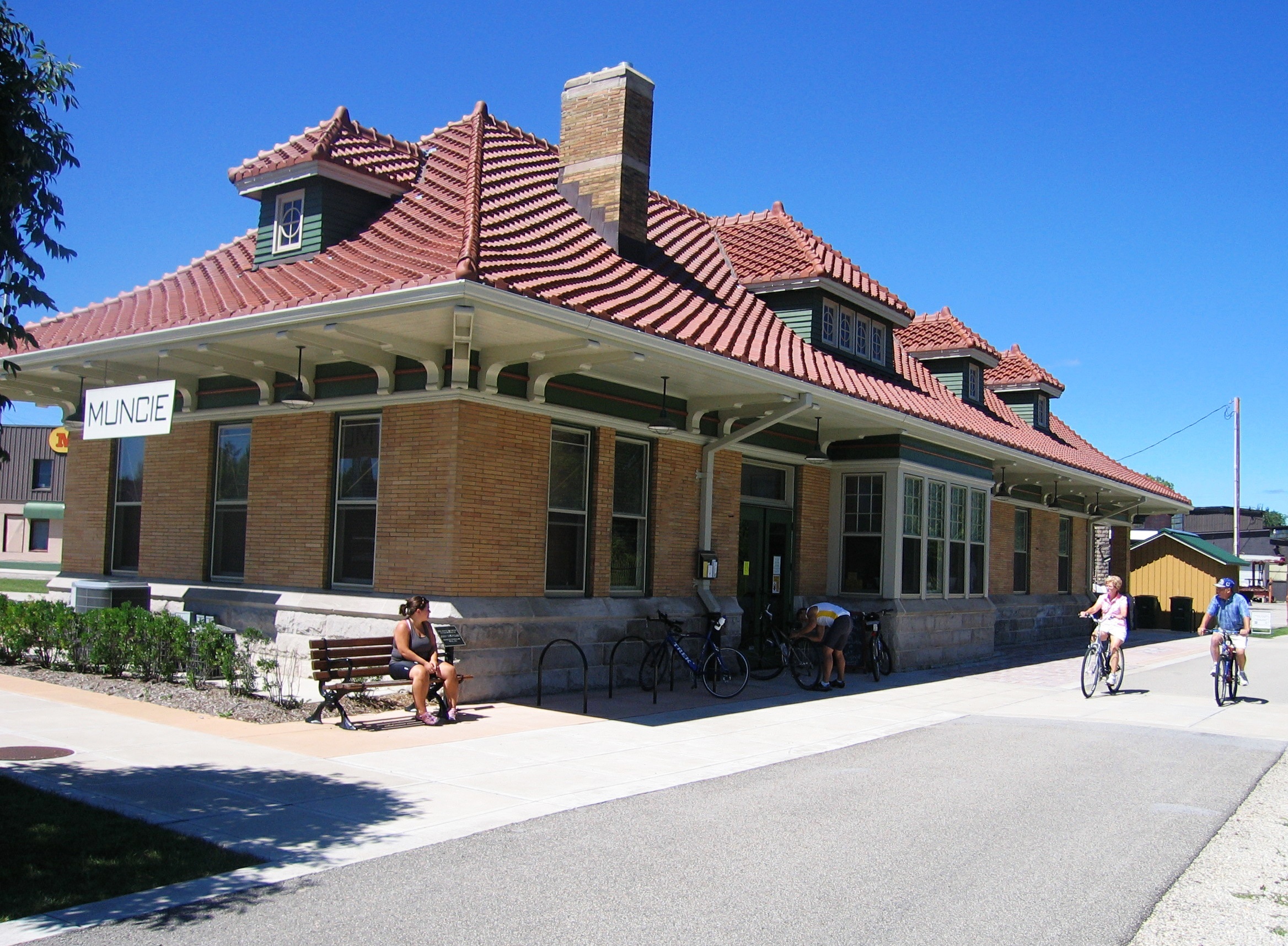 Bicyclists on the Cardinal Greenway pass by the Muncie trailhead in the restored Chesapeake and Ohio Depot (1904), listed on the National Register of Historic Places