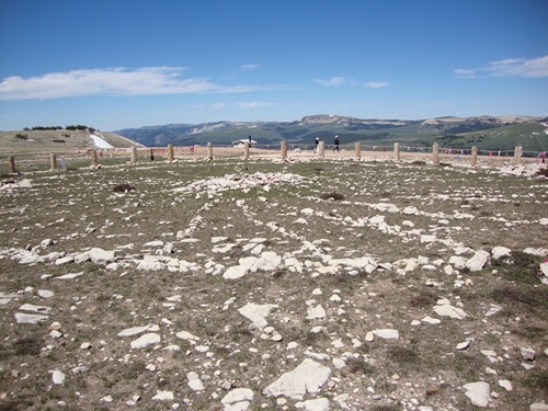 small stone circle with radial stone lines extending out to a larger stone circle