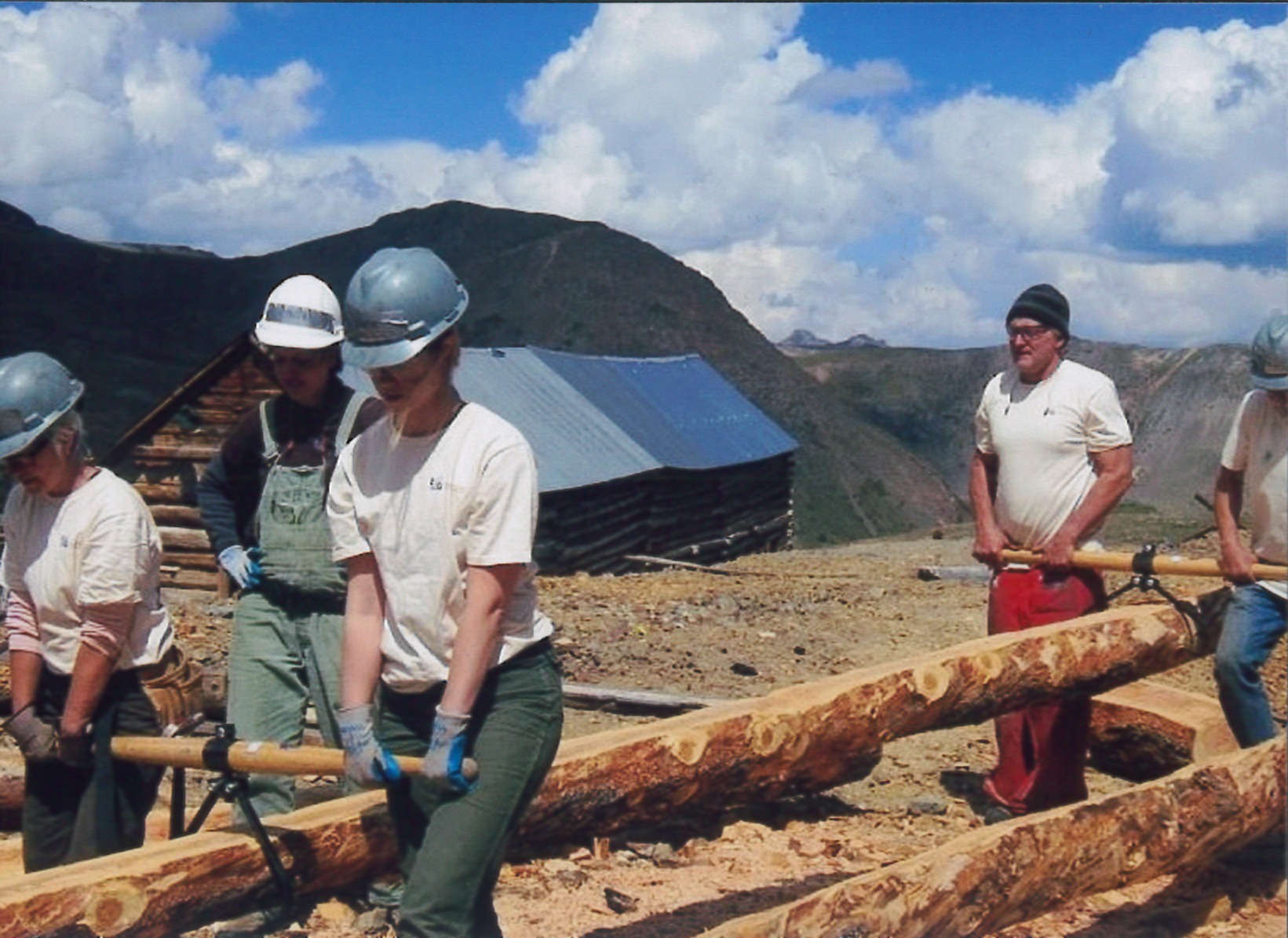 Volunteers shaping and installing logs at the Golconda Boarding House in Colorado's San Juan Mountains. (Photo credit: Rebecca Torsell.)