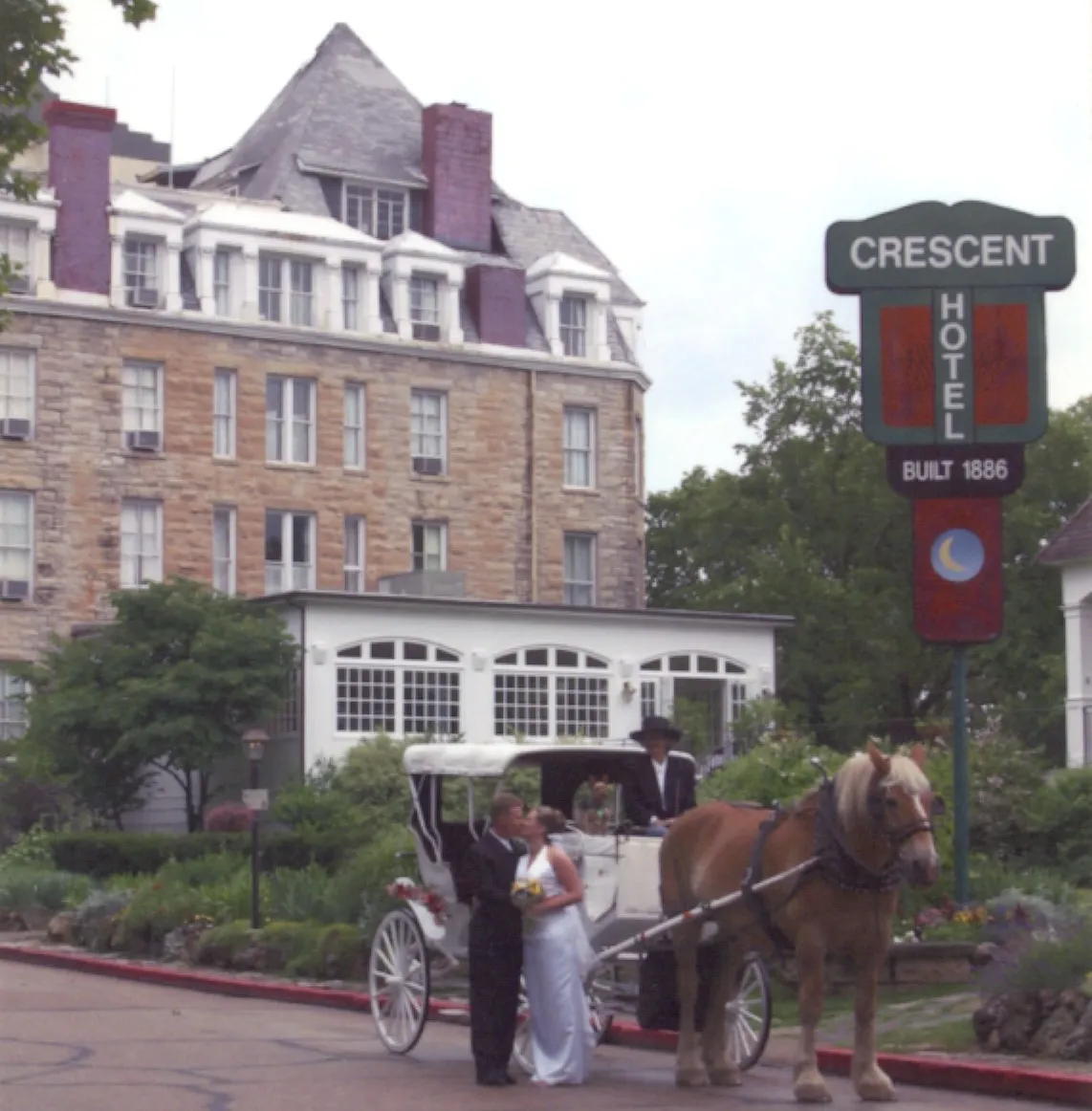 A newly married couple poses in front of the Crescent Hotel (1886) in historic Eureka Springs, Arkansas 