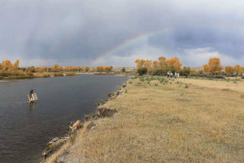 A rainbow arches over the archaeology crew at the river